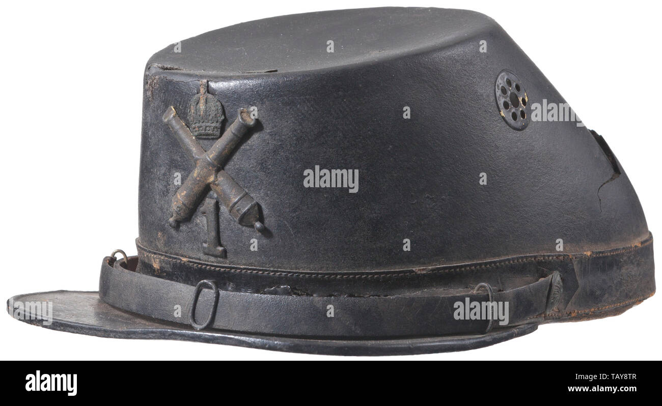 A French 1st artillery regiment shako for enlisted men, Black leather body and front visor (cracked in many pieces), black crowned cross cannons and '1', black leather chinstrap attached by two grenade button side posts (left side post not connected,) black leather sweatband, no liner, green paint with 'G' under front visor, interior label 'Bonet de Artilheria apre para a Lervico fora do Luartel'. USA-lot. 19th century, Europe, historic, historical 19th century, Additional-Rights-Clearance-Info-Not-Available Stock Photo