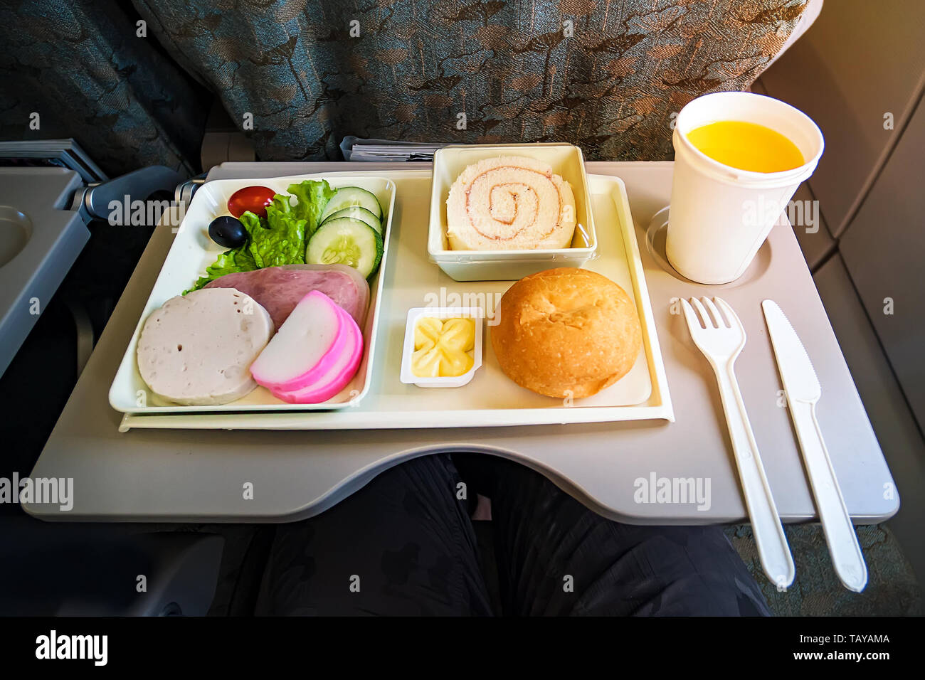 https://c8.alamy.com/comp/TAYAMA/inflight-meal-service-tray-for-economy-class-meat-fruit-salad-cucumber-a-glass-of-juice-and-butter-fork-and-knife-made-of-plastic-for-safety-TAYAMA.jpg