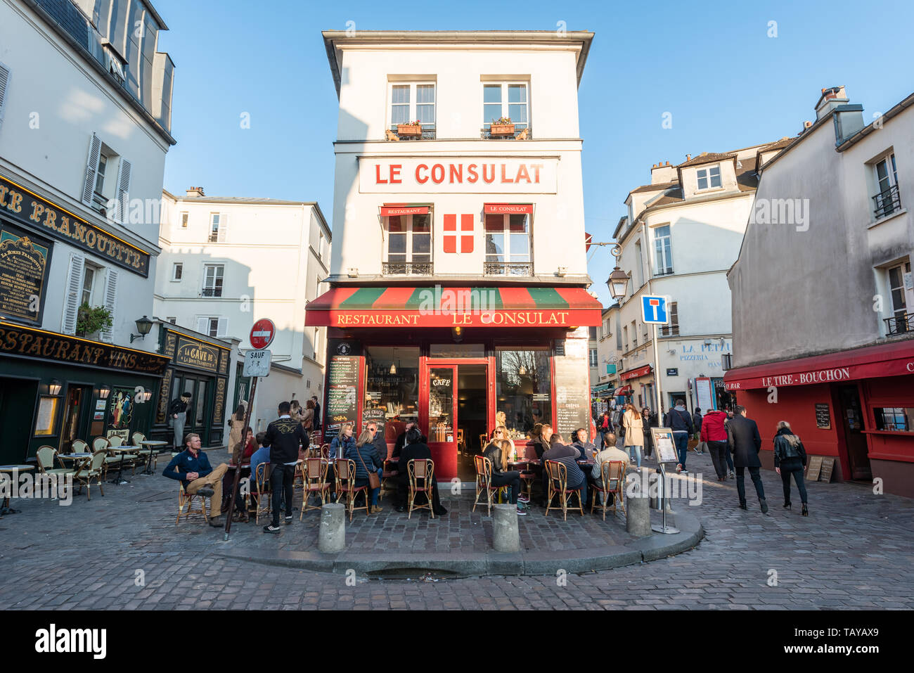 Paris, France - April 12, 2019 : People sitting at the terrace of Le consulat restaurant in Montmartre in the evening on a sunny day Stock Photo