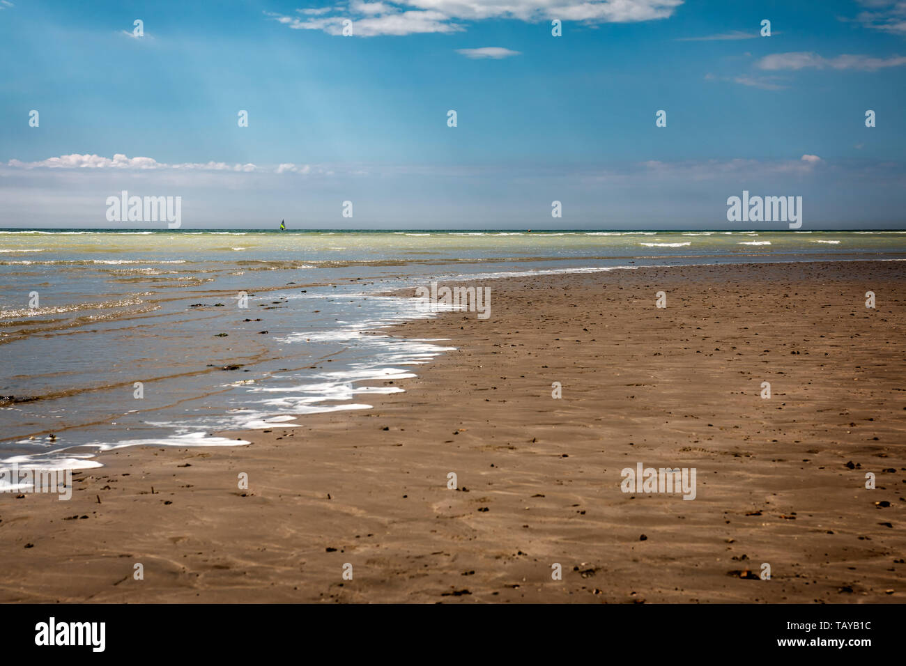 Empty beach with the sea lapping on a sandy beach in Worthing, West Sussex, UK Stock Photo