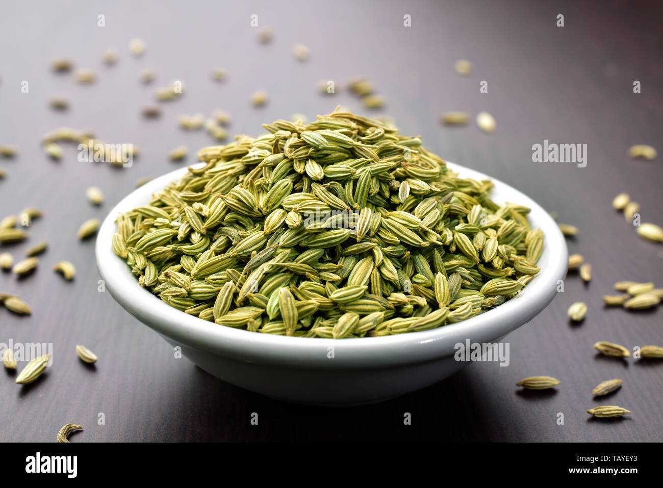 Fennel seeds in a bowl on a wooden table Stock Photo
