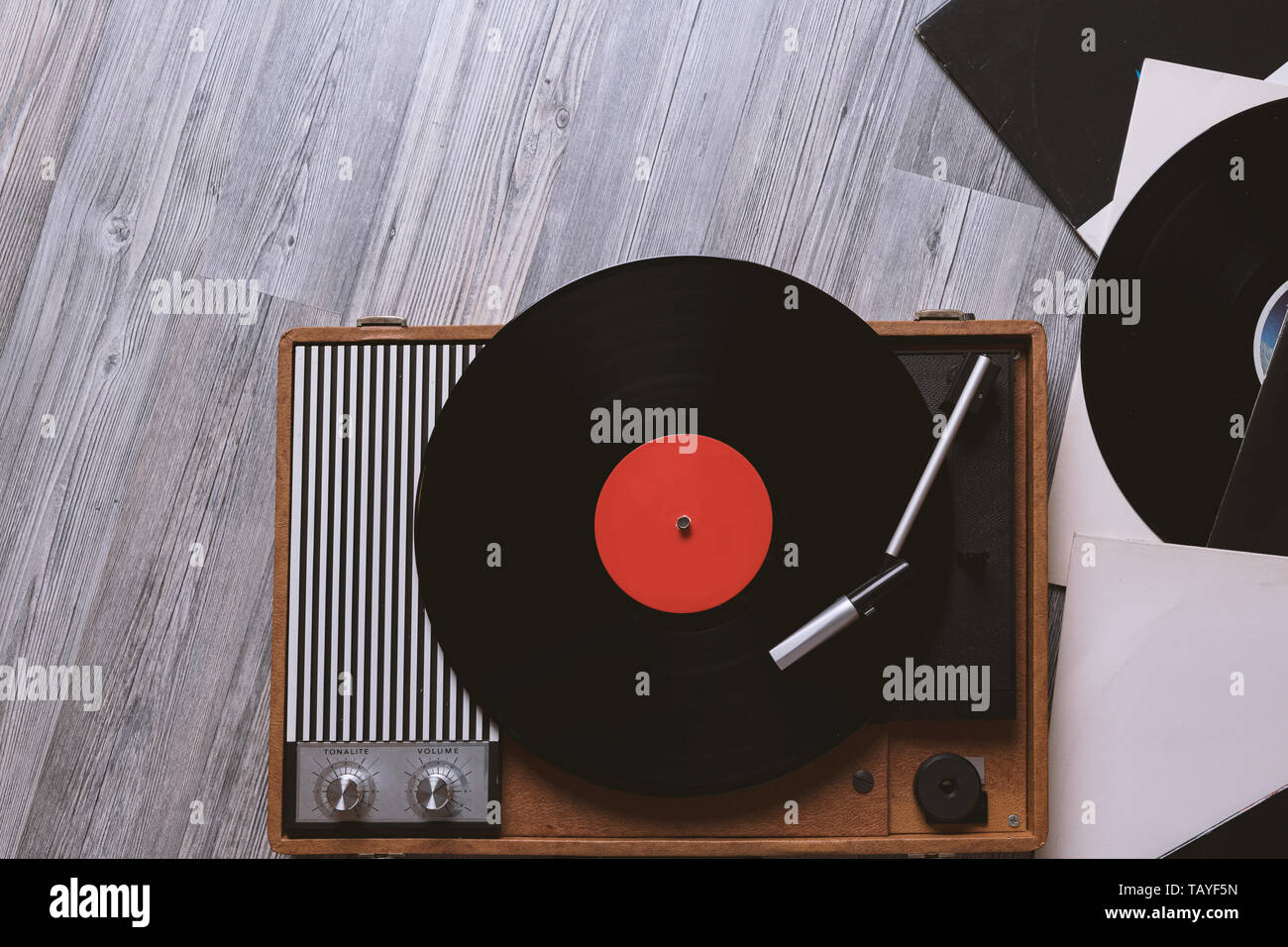 Vintage turntable with a vinyl record on gray wooden table, top view ...