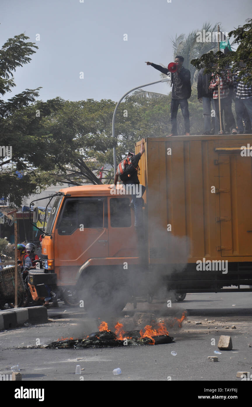 A demonstrant climbs on a truck during students rally in front of Muhammadiah University at Allaudin Street. University students all over Indonesia ho Stock Photo