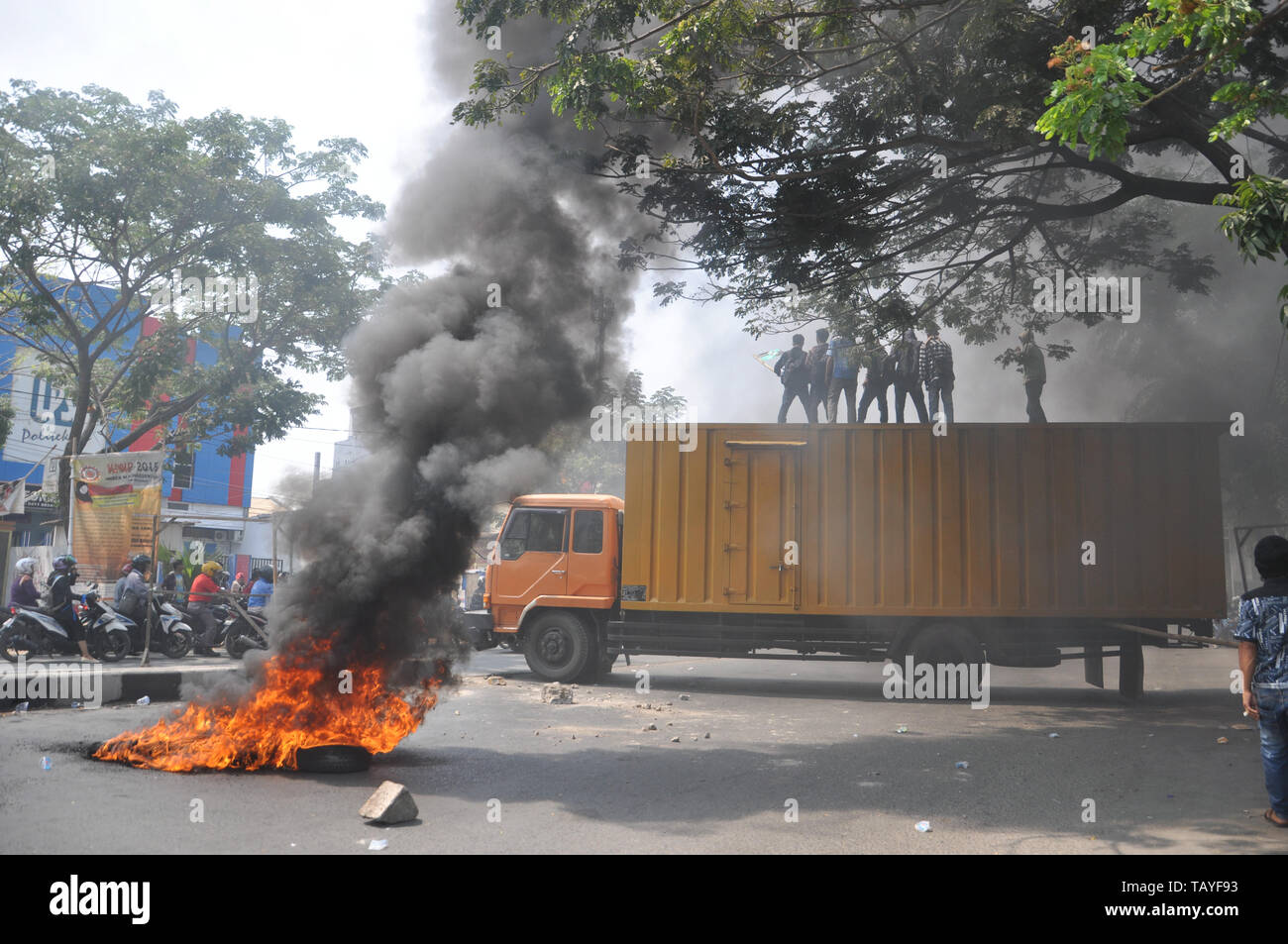 Black smoke billows from burned tires during students rally in front of Muhammadiah University at Allaudin Street. University students all over Indone Stock Photo