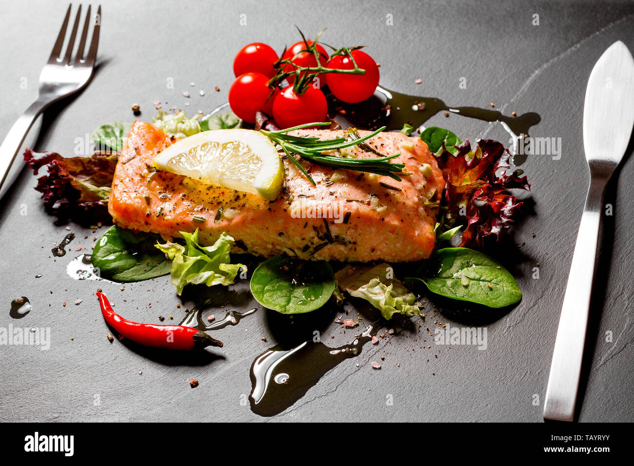 Grilled salmon fillet with salad on black slate plate Stock Photo - Alamy