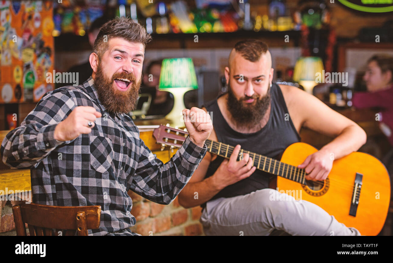 Man play guitar in pub. Cheerful friends sing song guitar music. Relaxation in pub. Friends