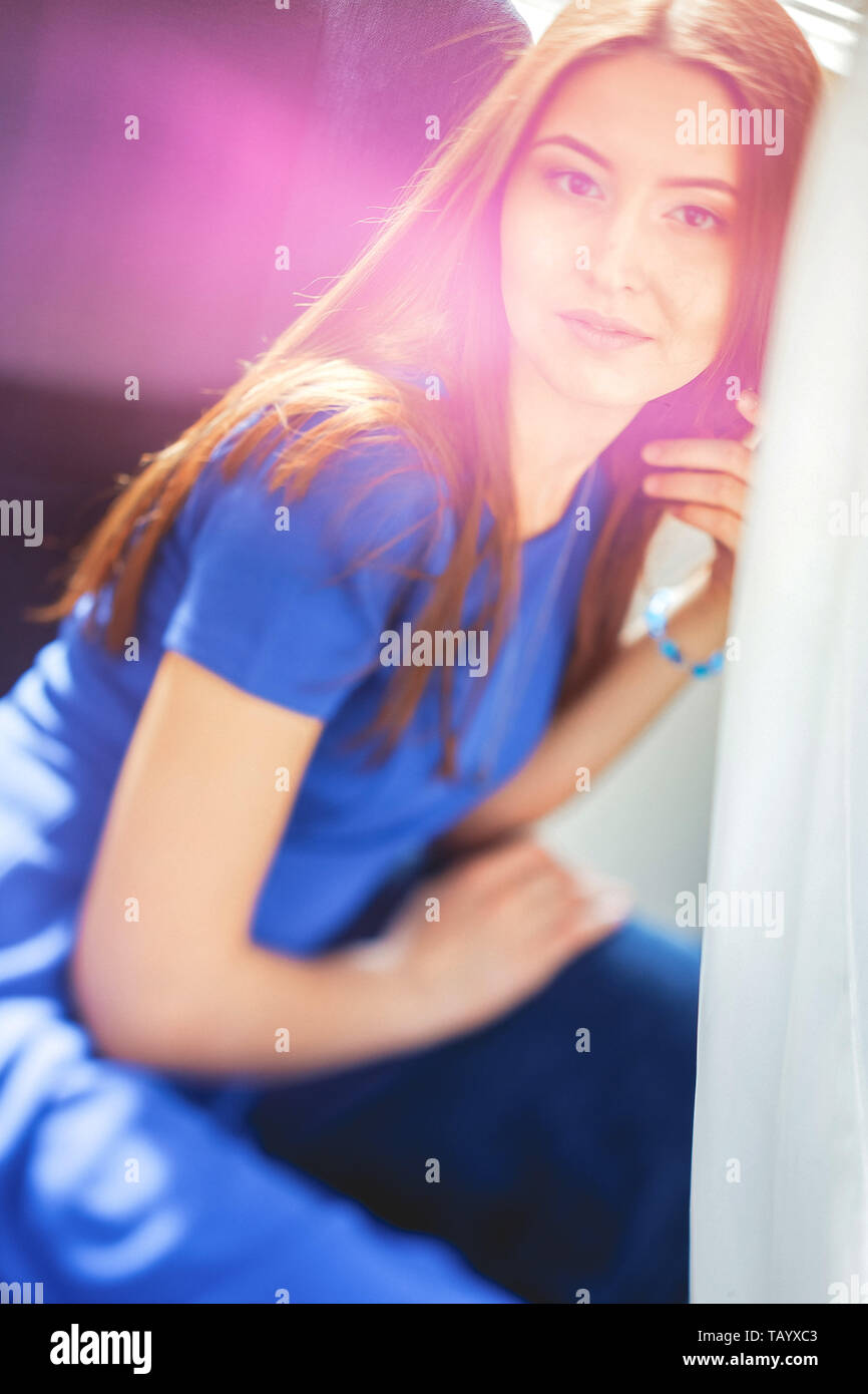 Young smiling woman sitting on chair Stock Photo - Alamy