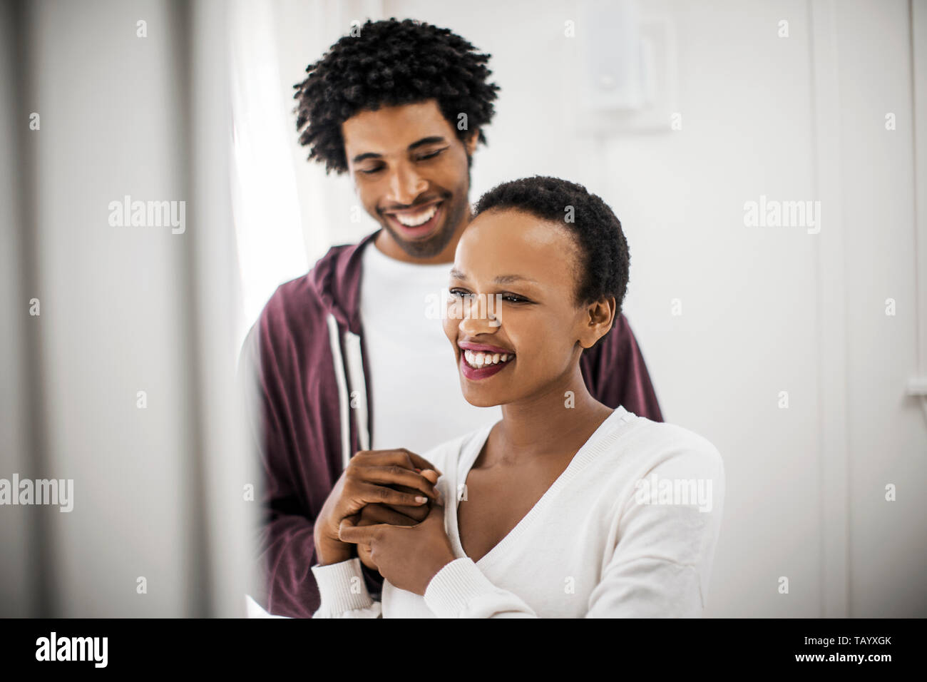 Smiling young couple holding hands Stock Photo - Alamy