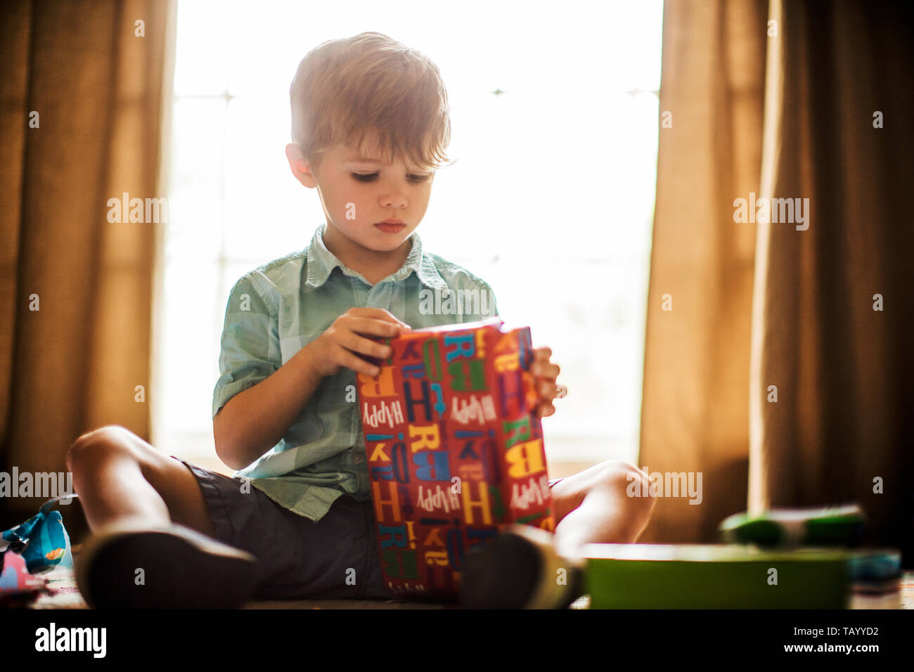 Young boy opening birthday presents. Stock Photo