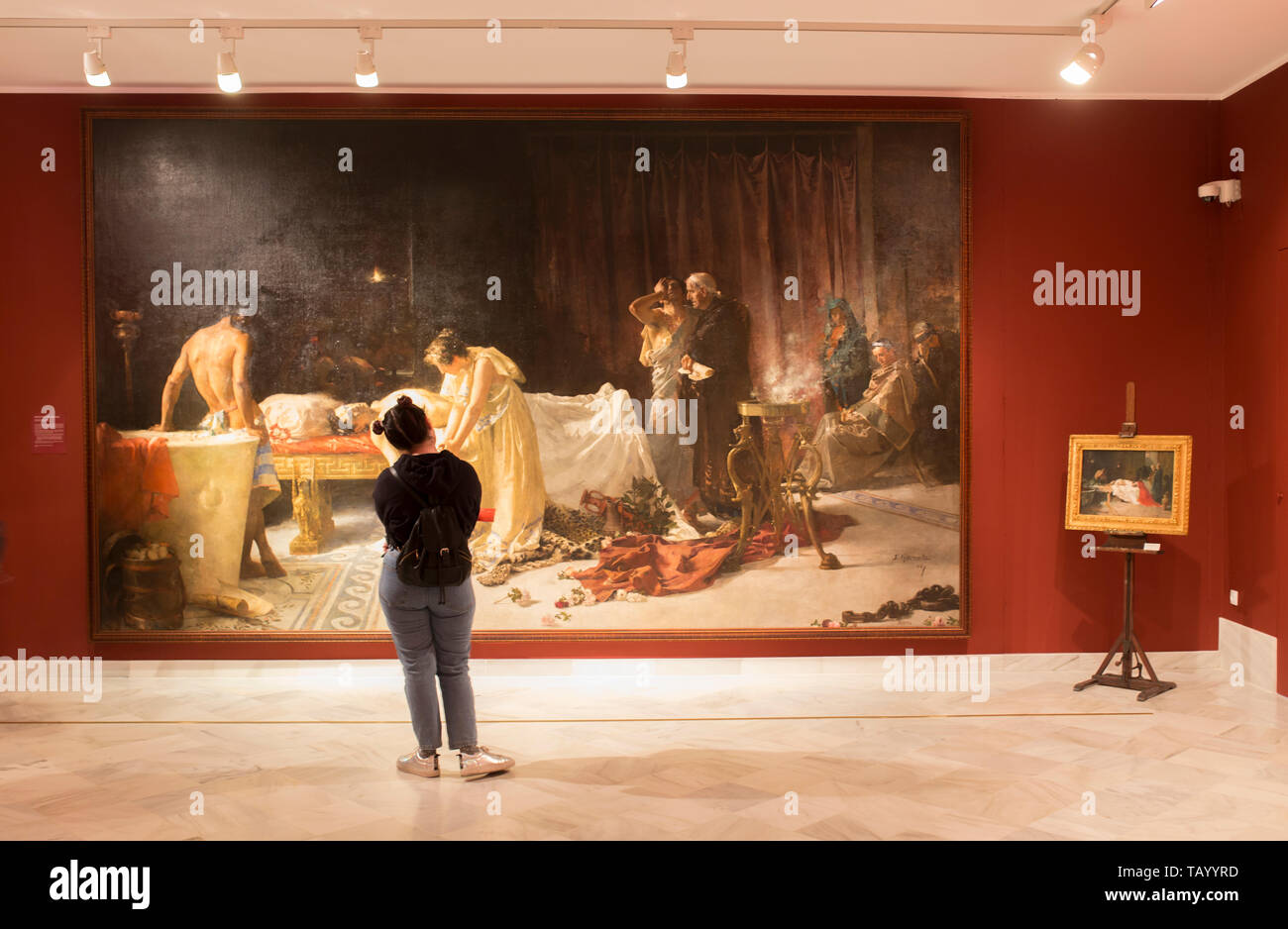 Montilla, Spain - March 2nd, 2019: Young woman observing Lucan death painting at Jose Garnelo Museum. Cordoba, Spain Stock Photo