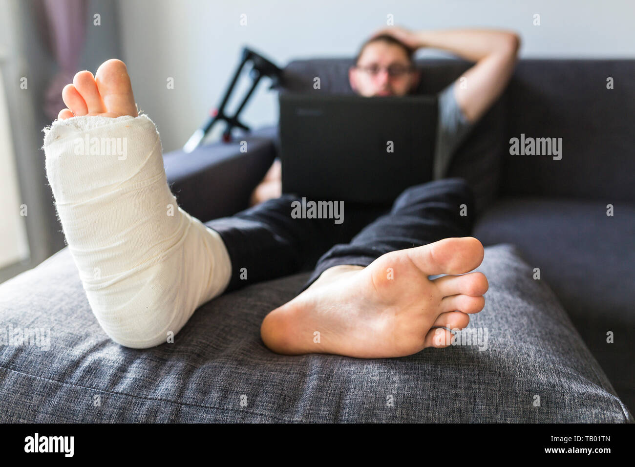 man with a broken leg is surfing the internet Stock Photo
