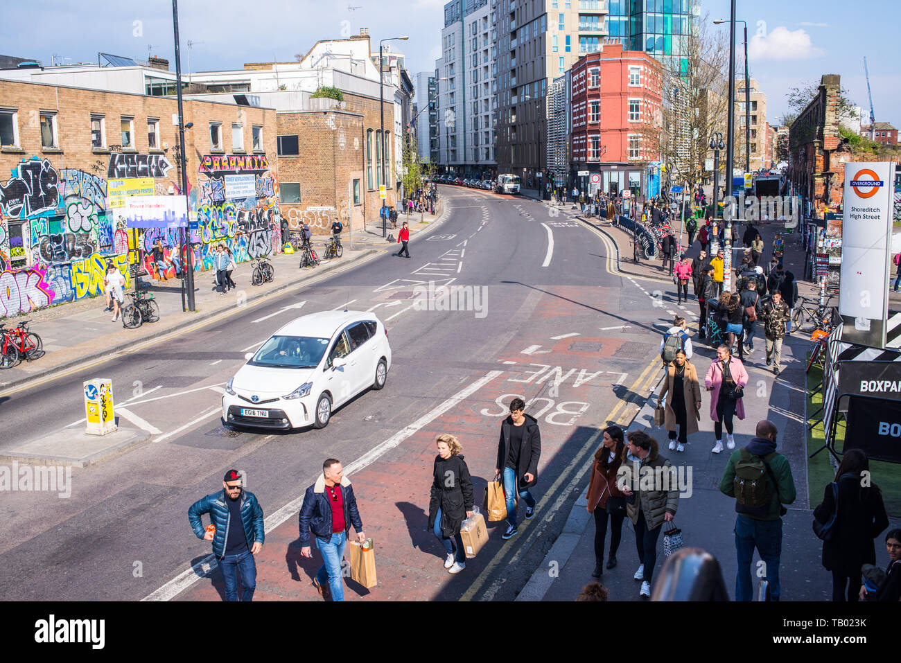 Shoreditch, London, England, UK - April 2019: People walking on Bethnal Green Road near Shoreditch high street station and BOXPARK in Shoreditch Stock Photo