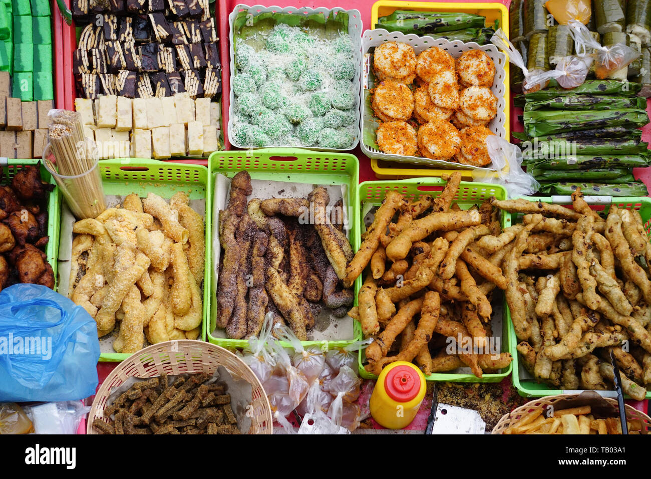 Variety of delicious and colorful Malaysian home cooked local cakes or 'kueh' sold at street market stall in Kota Kinabalu Sabah from top angle view. Stock Photo