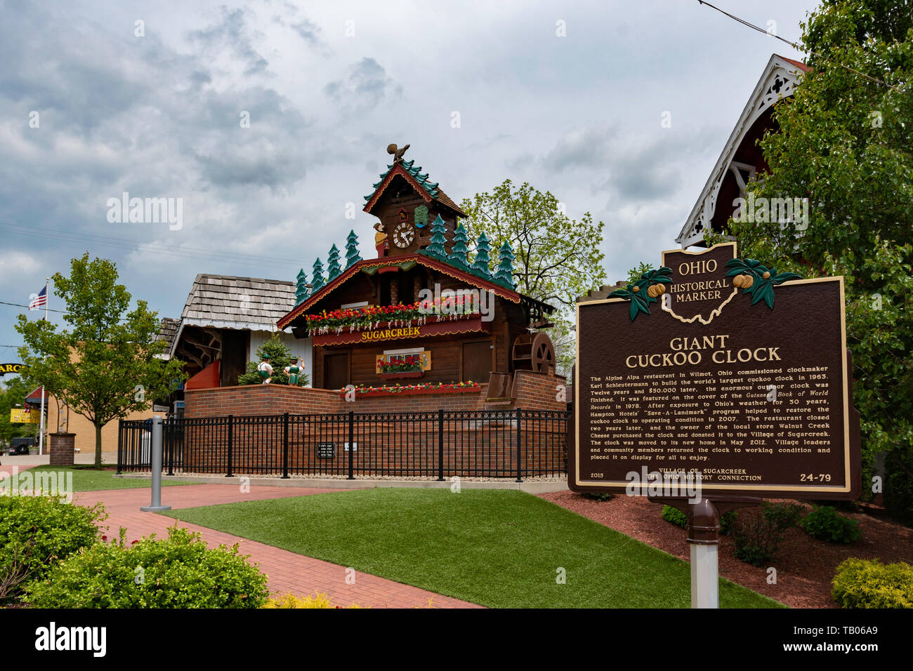 Sugarcreek Ohio/USA-May 16, 2019: Historical marker for the Giant Cuckoo Clock with the actual clock in the background in downtown Sugarcreek. Sugarcr Stock Photo