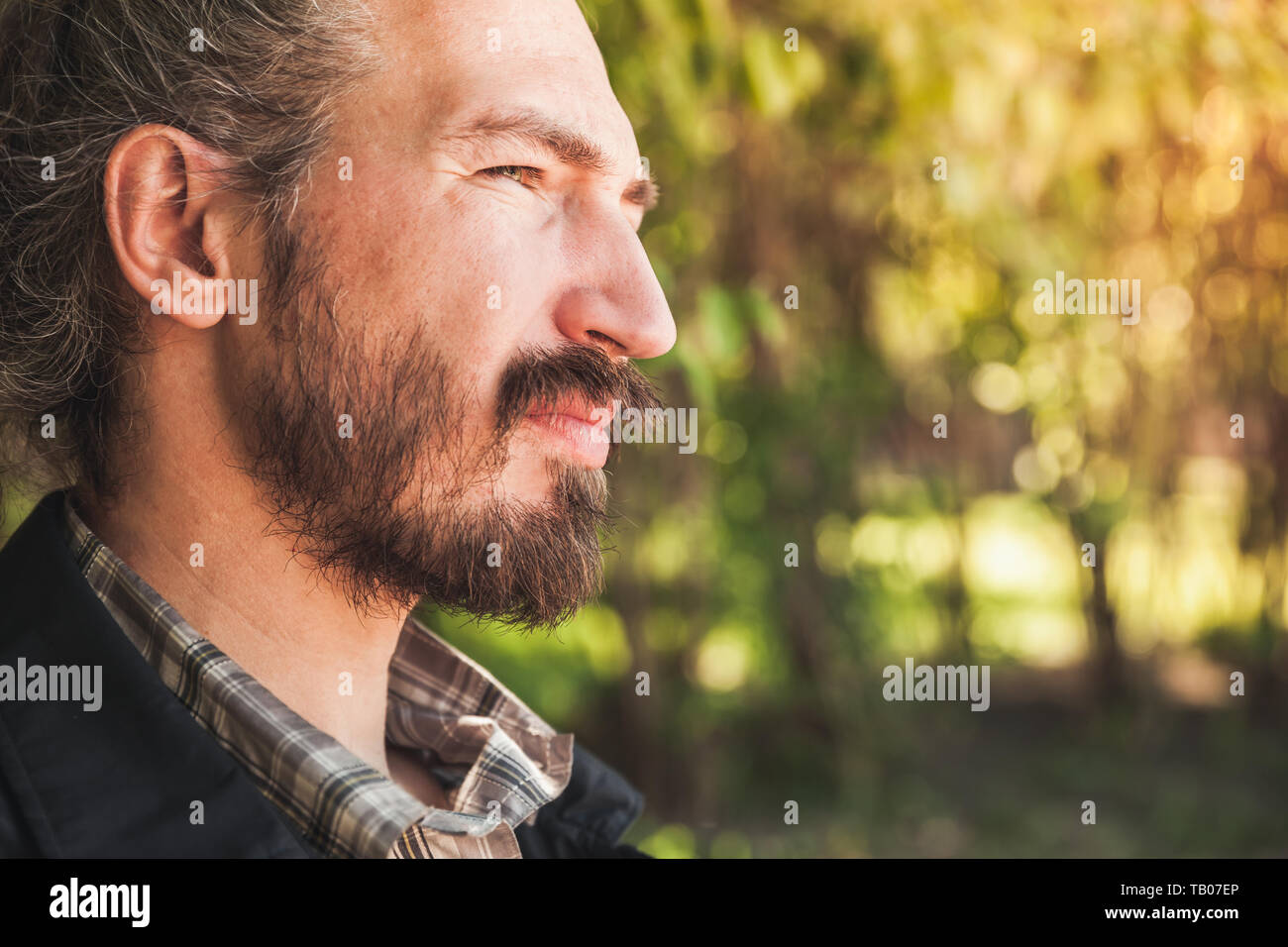 Young adult bearded Asian man, close up outdoor portrait at summer day Stock Photo