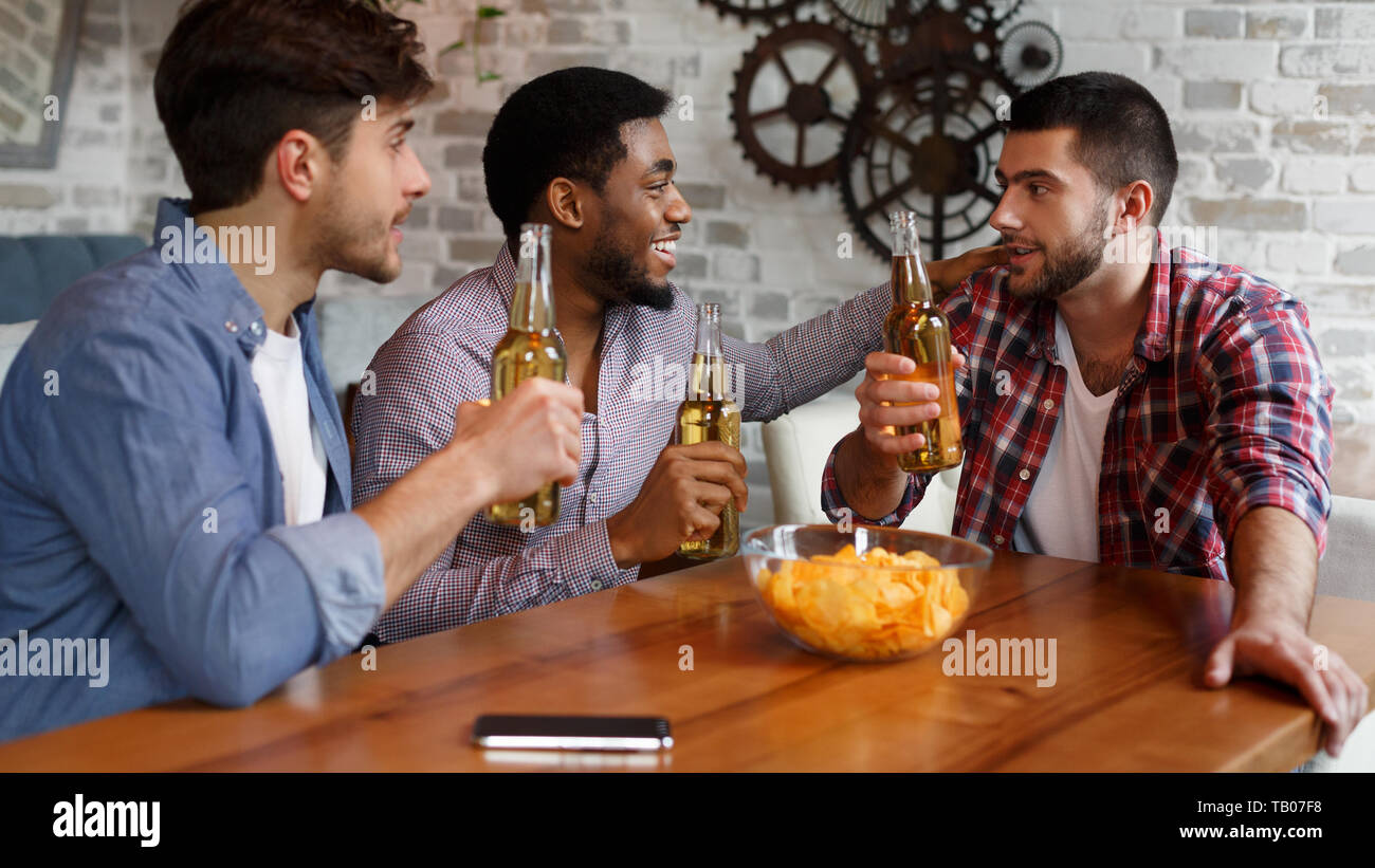 Mates Eating Chips And Drinking Beer In Pub Stock Photo