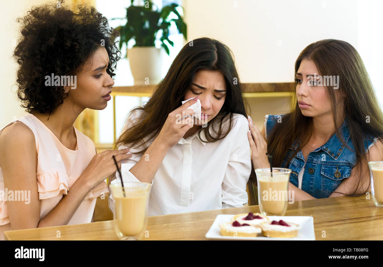 Two friends cheering up young depressed girl Stock Photo - Alamy