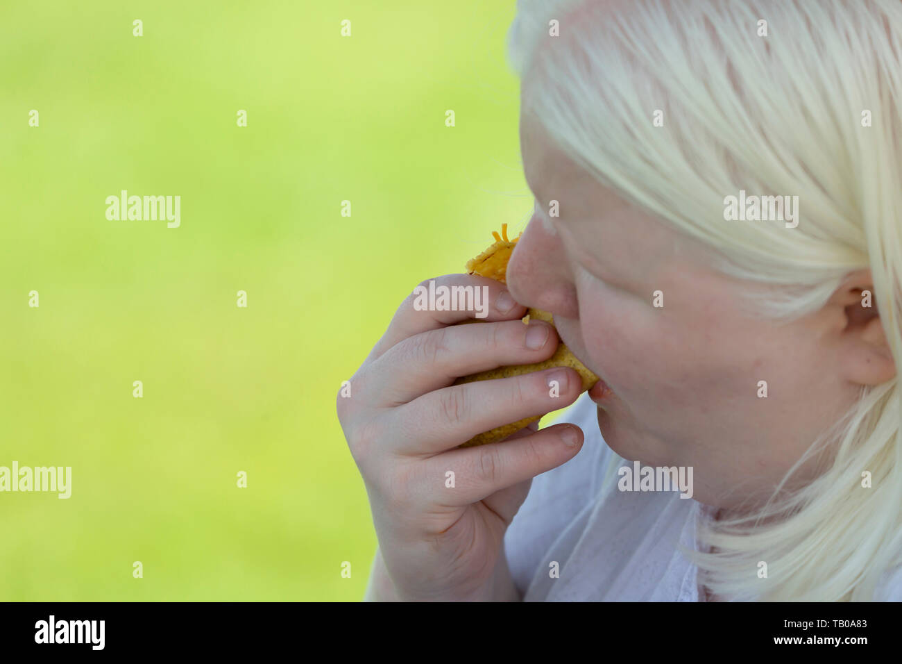 Close up of an albino woman eating taco outdoors Stock Photo