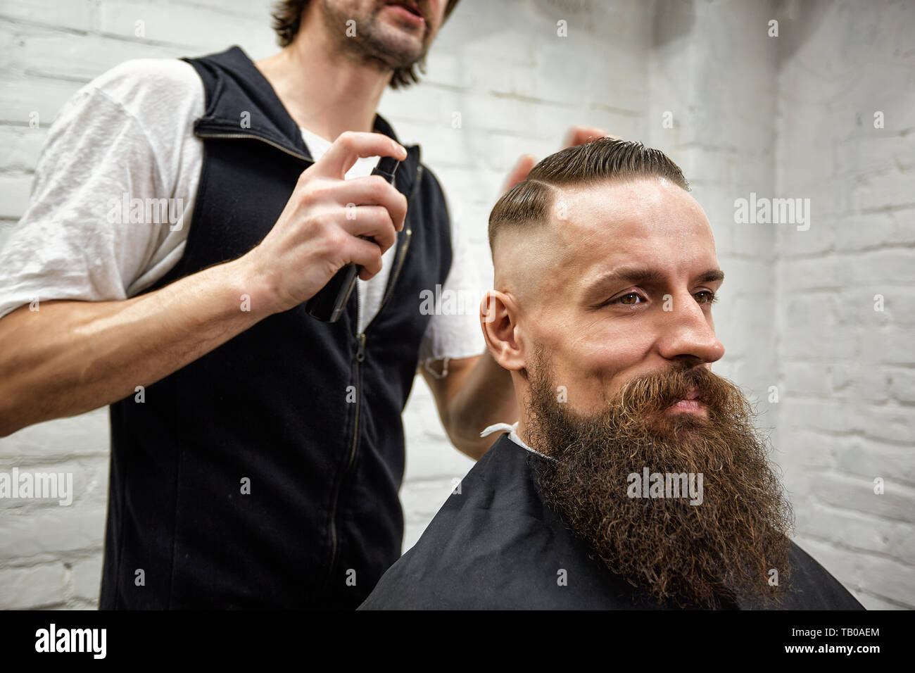 Master Cuts Hair And Beard Of Men In The Barbershop Hairdresser