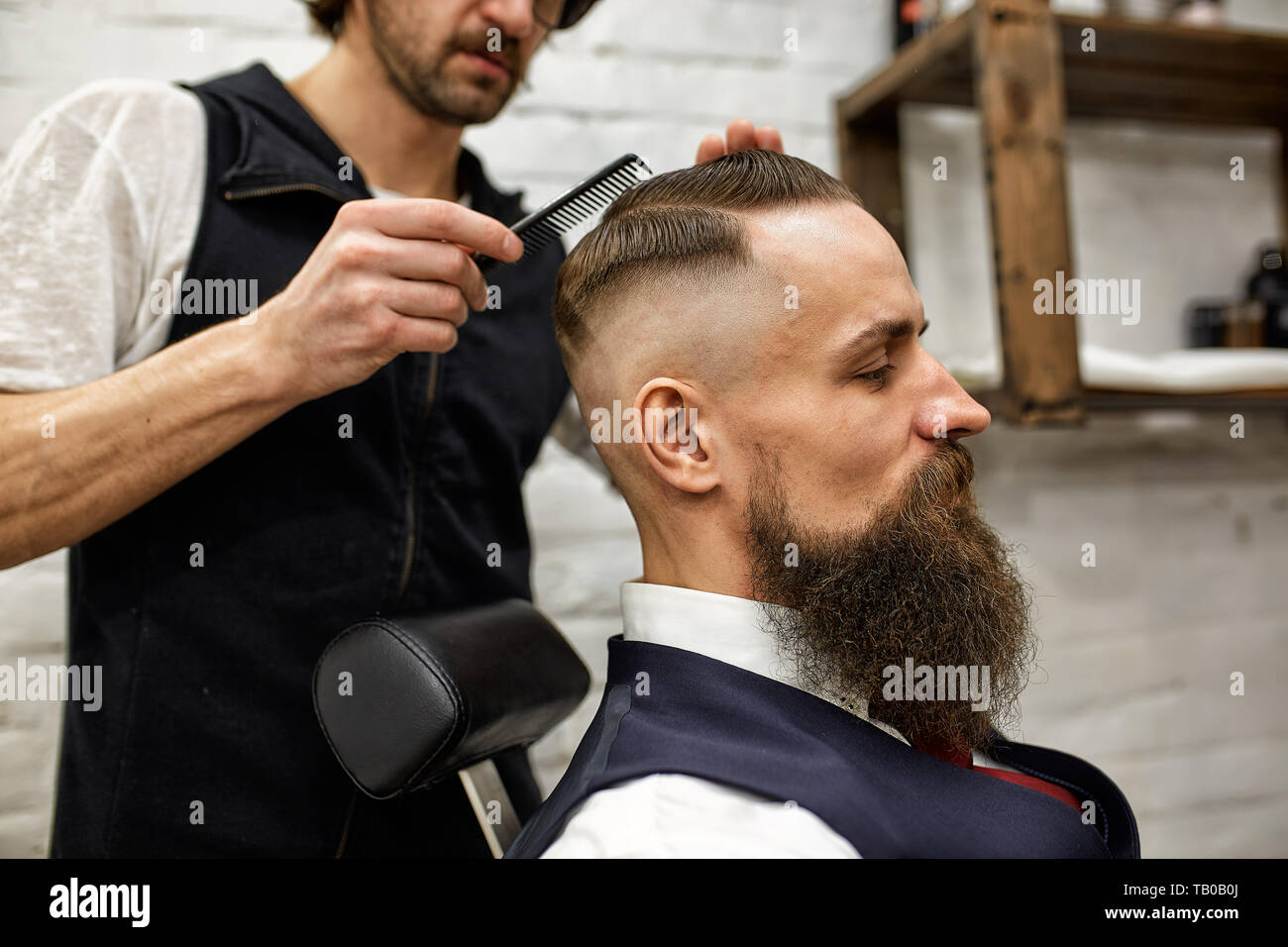 Master Cuts Hair And Beard Of Men In The Barbershop Hairdresser
