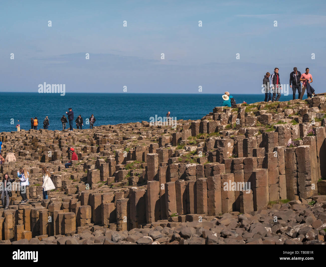 People climb on the rocks of the famous Giants Causeway in Northern ...