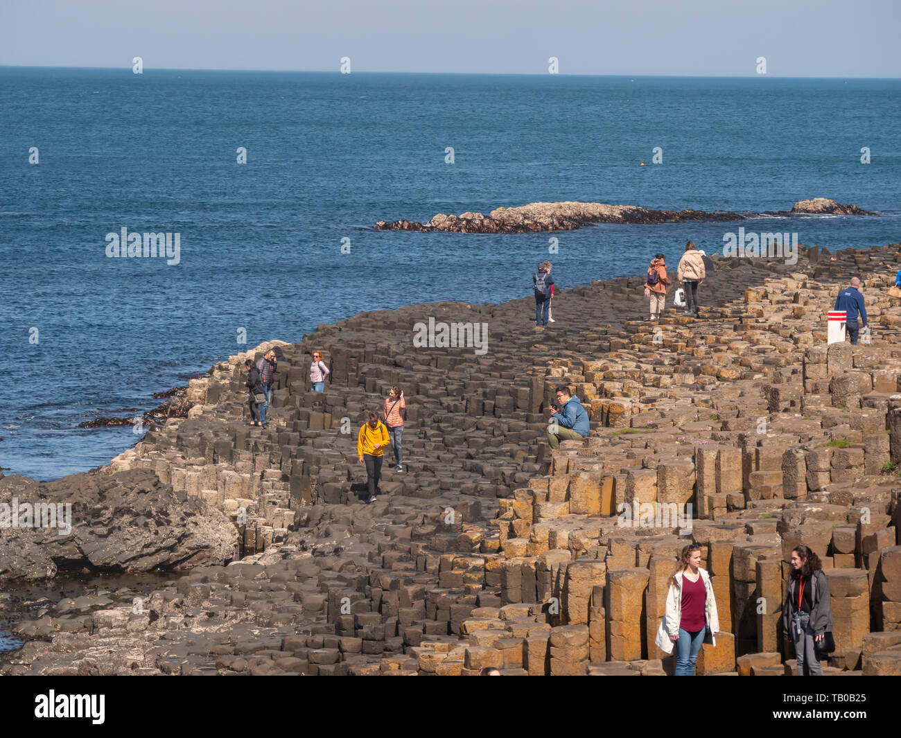 People climb on the rocks of the famous Giants Causeway in Northern ...