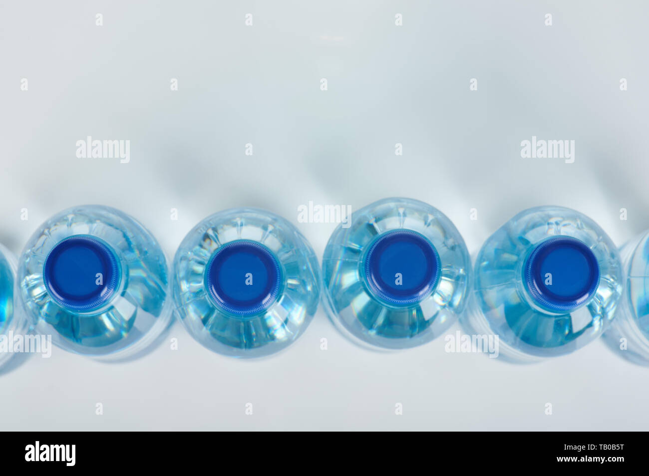 Cap of blue plastic bottles above top view Stock Photo