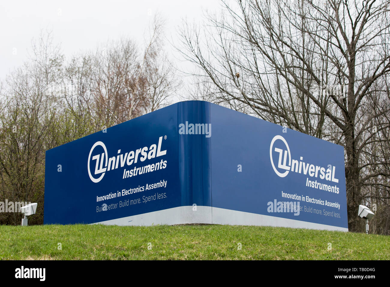 A logo sign outside of the headquarters of Universal Instruments in