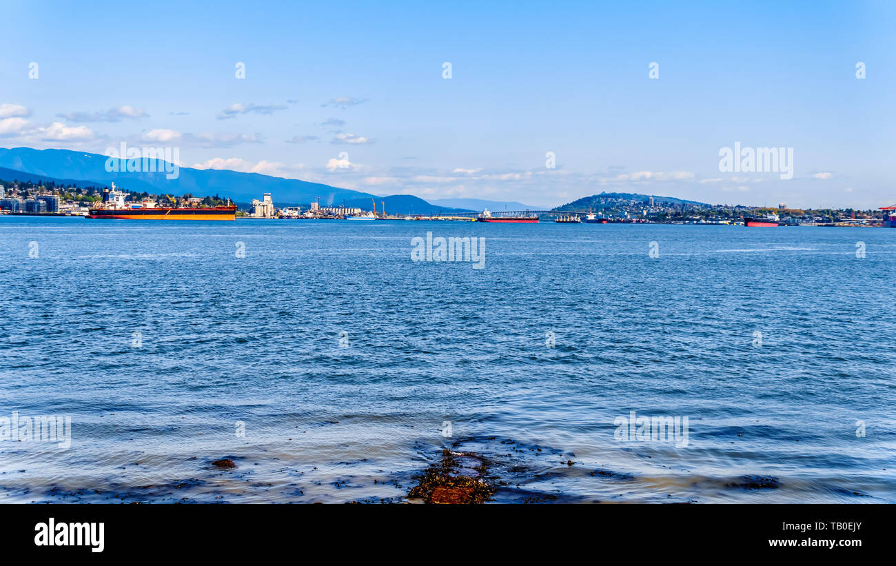View of the North Shore of Vancouver Harbor viewed from the Stanley Park Seawall pathway with Mount Seymour in the background in beautiful BC, Canada Stock Photo
