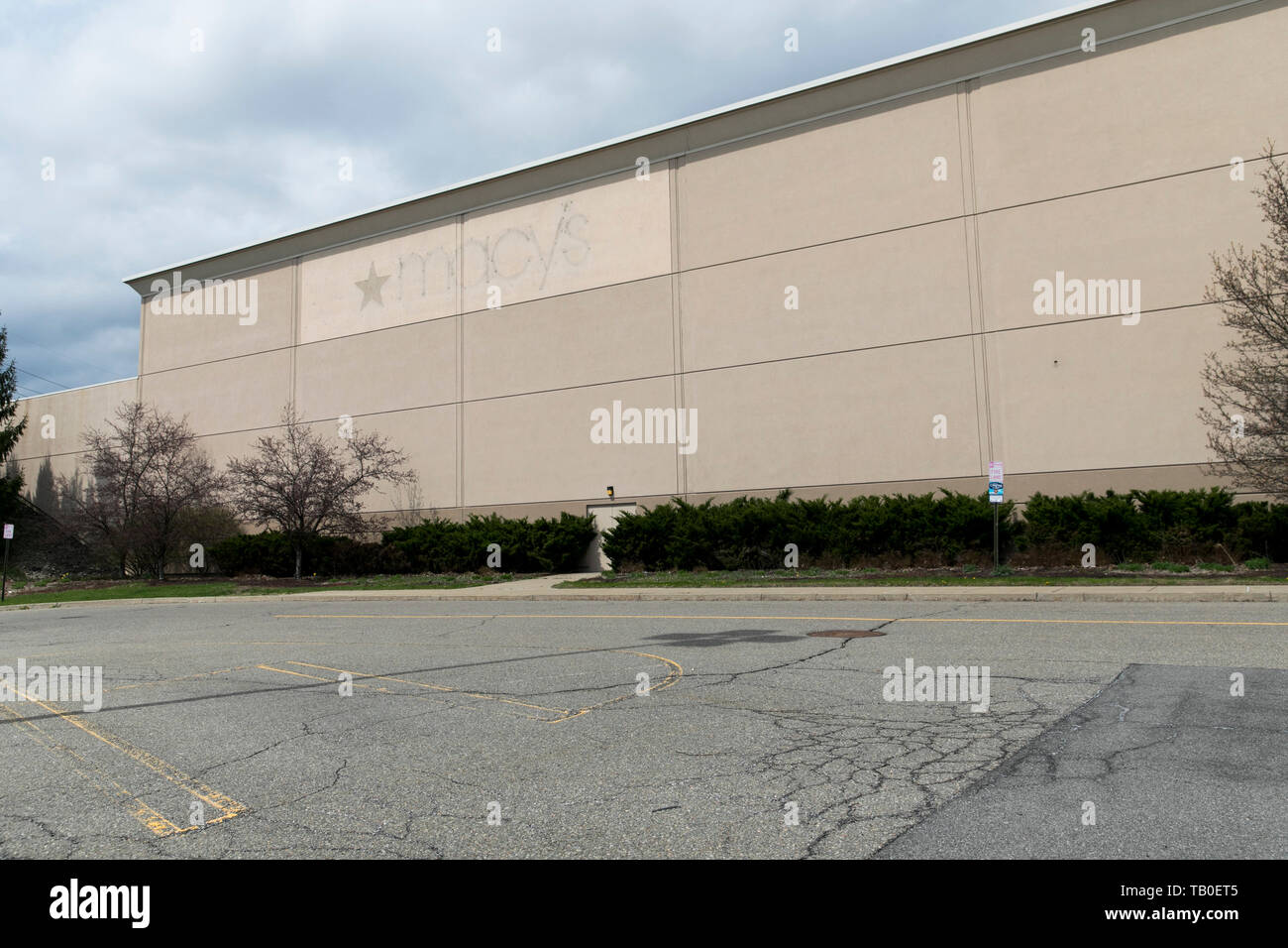 The outline of a Macy’s logo sign outside of a closed retail store