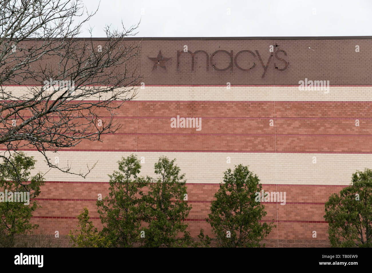 The outline of a Macy’s logo sign outside of a closed retail store