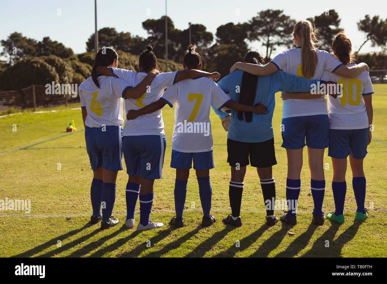 Female soccer players standing with arm around at sports field Stock ...