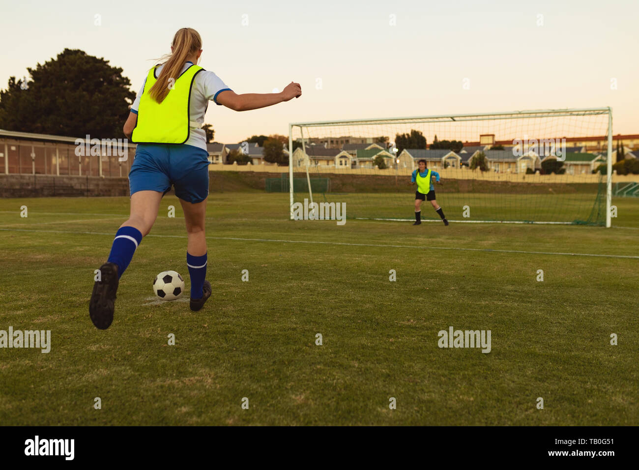 Players playing soccer at sports field Stock Photo