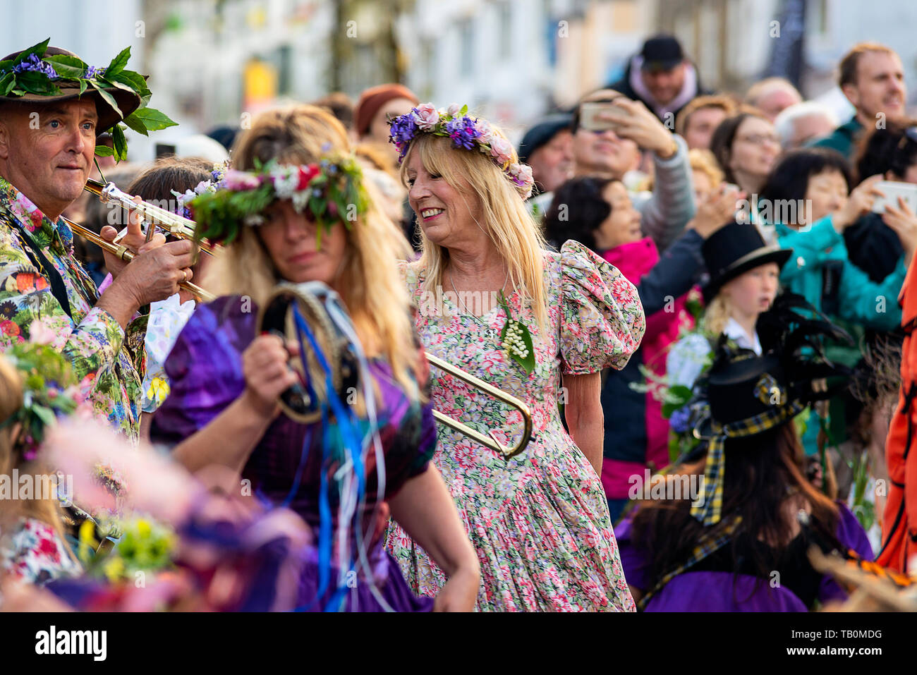 Editorial: Unknown members of the public, potential logo and other trademarks. Helston, Cornwall, UK. Dancers make their way through the streets of He Stock Photo