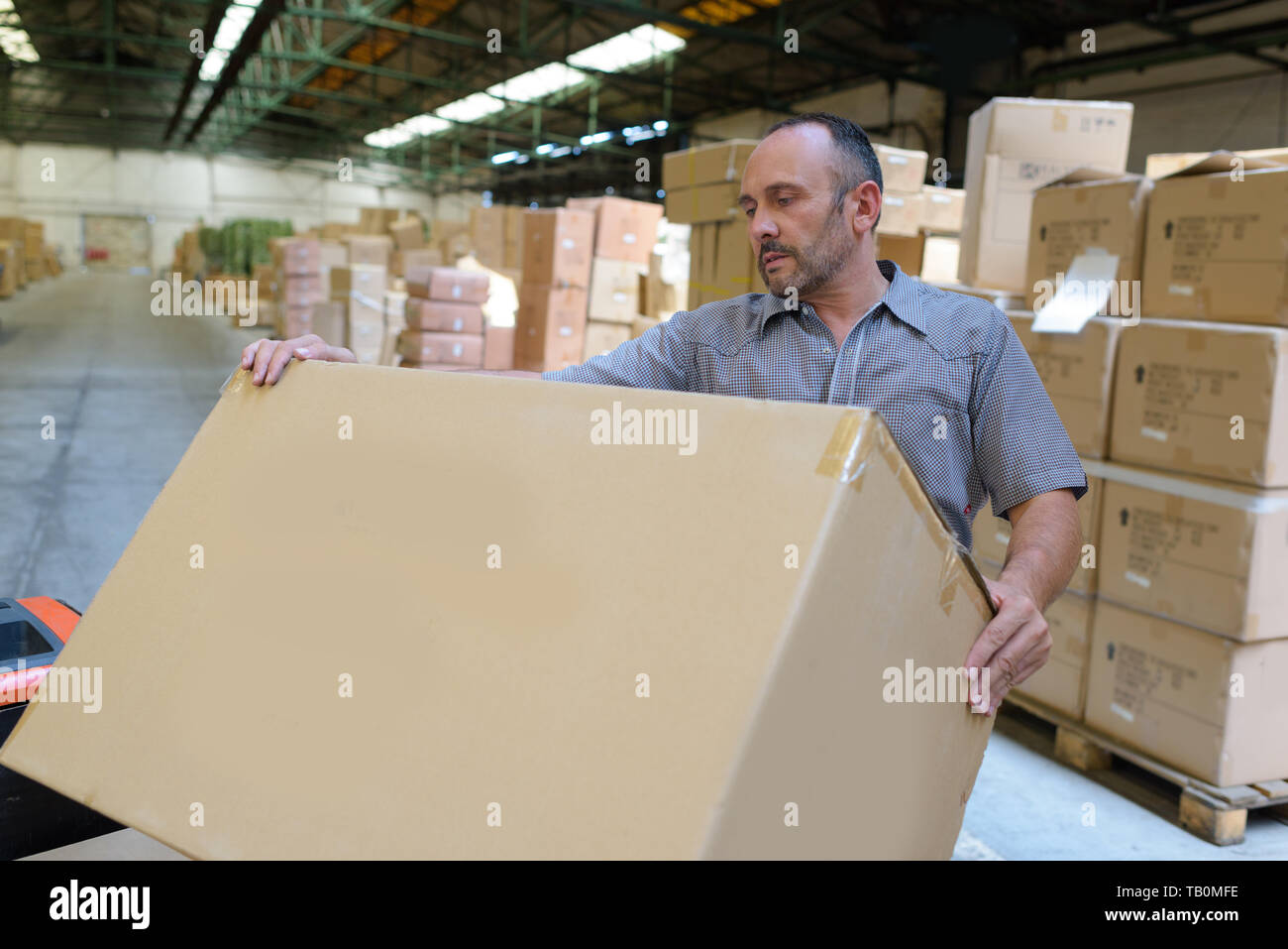 porter carrying boxes in a warehouse Stock Photo Alamy