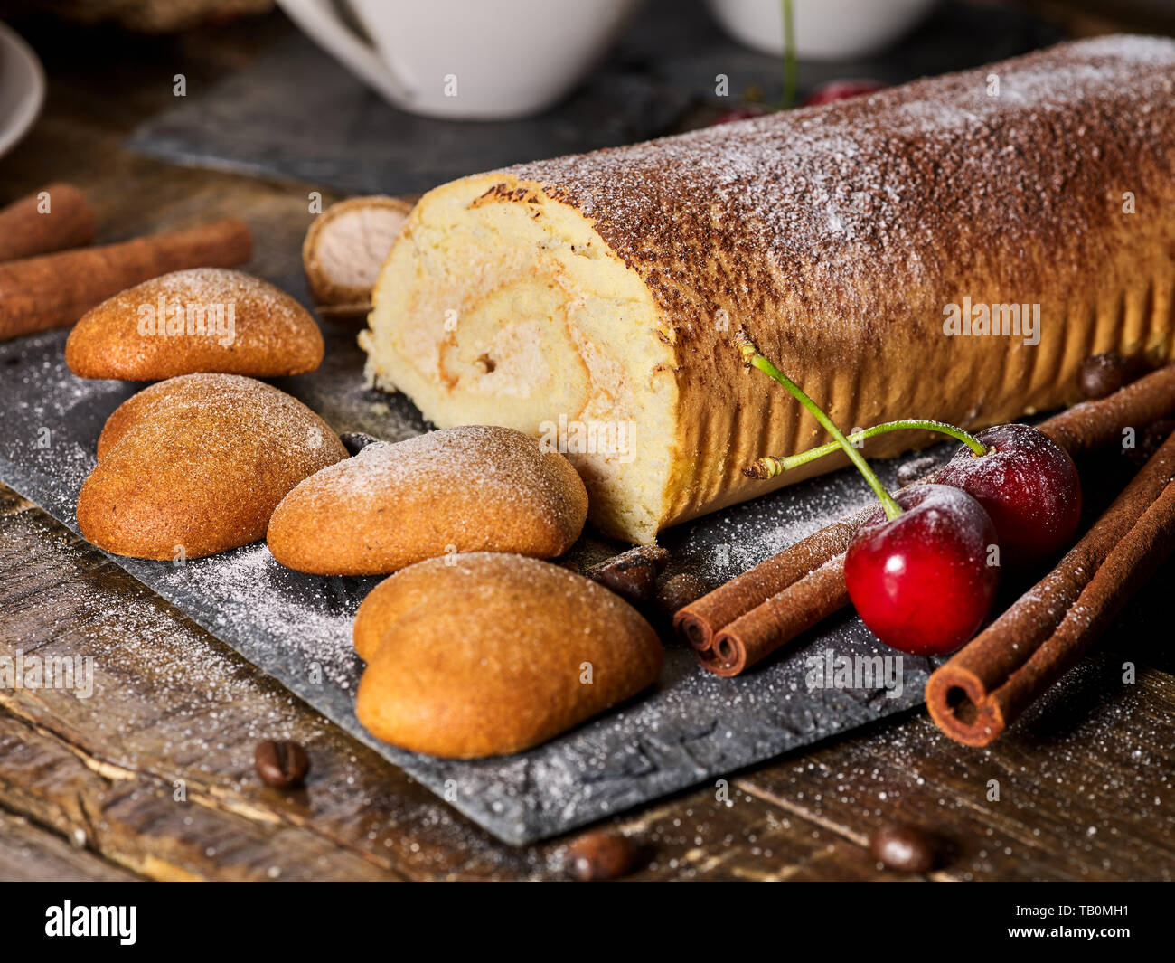 Oatmeal cookies ,rolled cake on tier cake stand with cherry Stock Photo