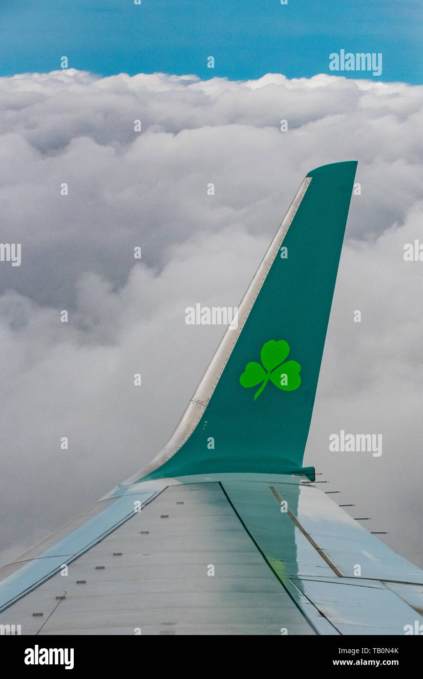 Aer Lingus A320 airplane wing above the clouds - aer lingus logo - airplane above clouds - airplane wing in clouds Stock Photo