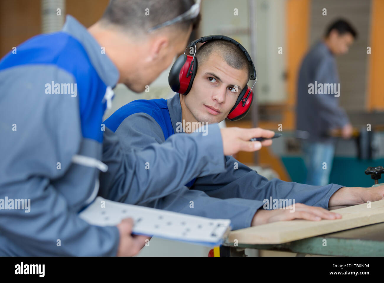 mechanic showing parts of an engine to apprentice Stock Photo - Alamy