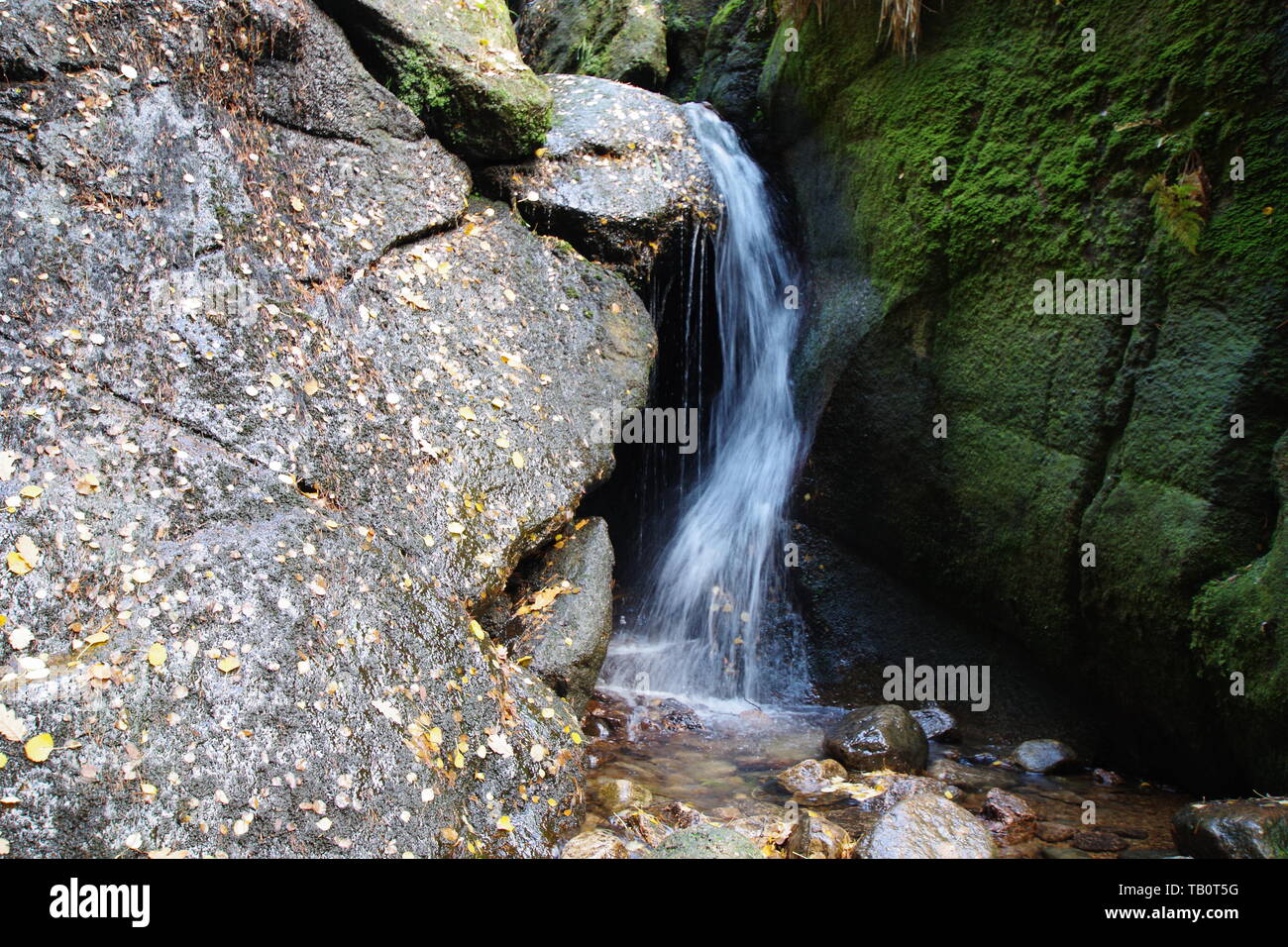 Waterfall at the Burn O'Vat Glacial Pothole on an Autumn Day. Muir of Dinnet NNR, Cairngorms, Scotland, UK. Stock Photo