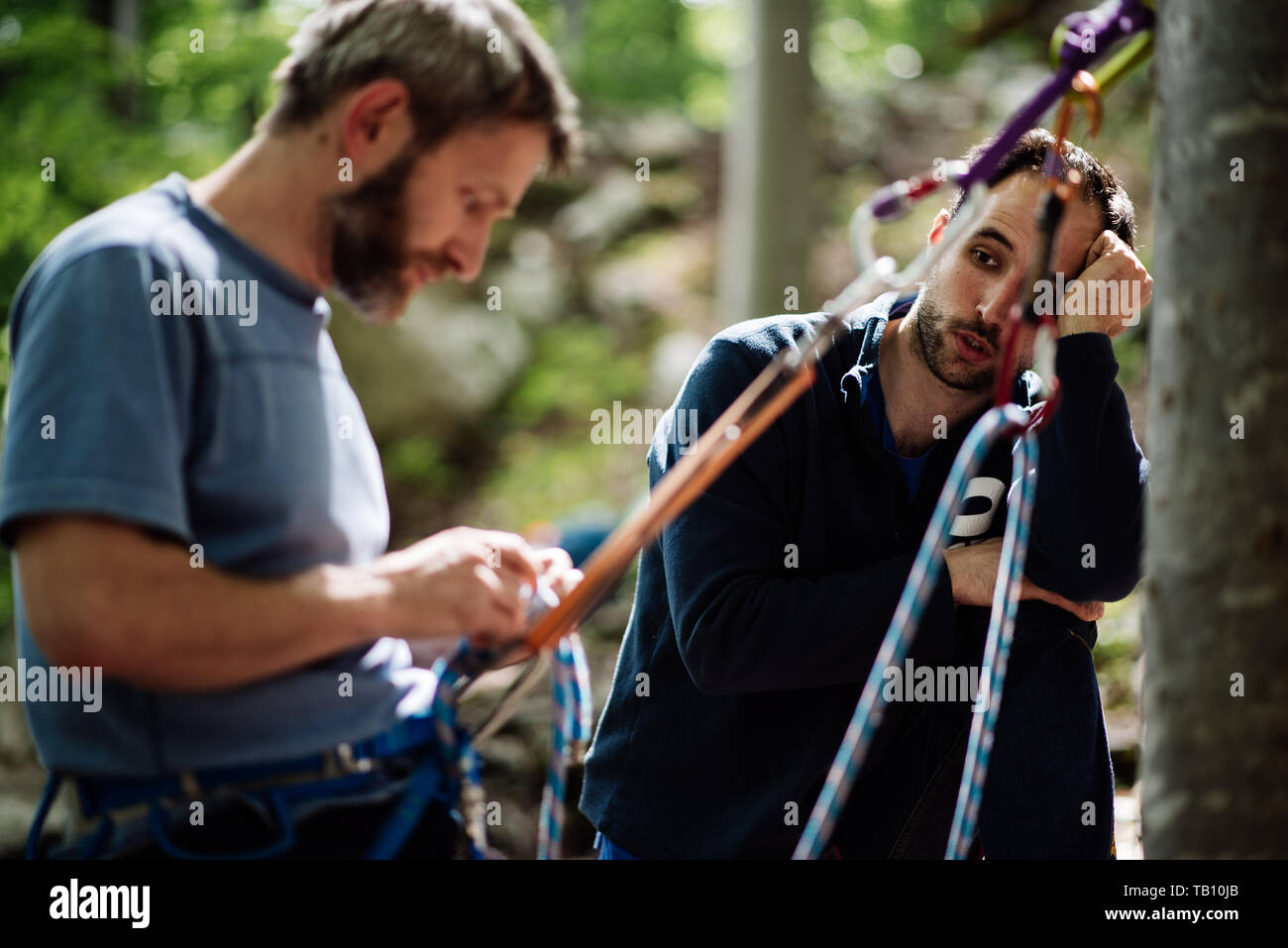 Two men practicing climbing techniques with rope Stock Photo