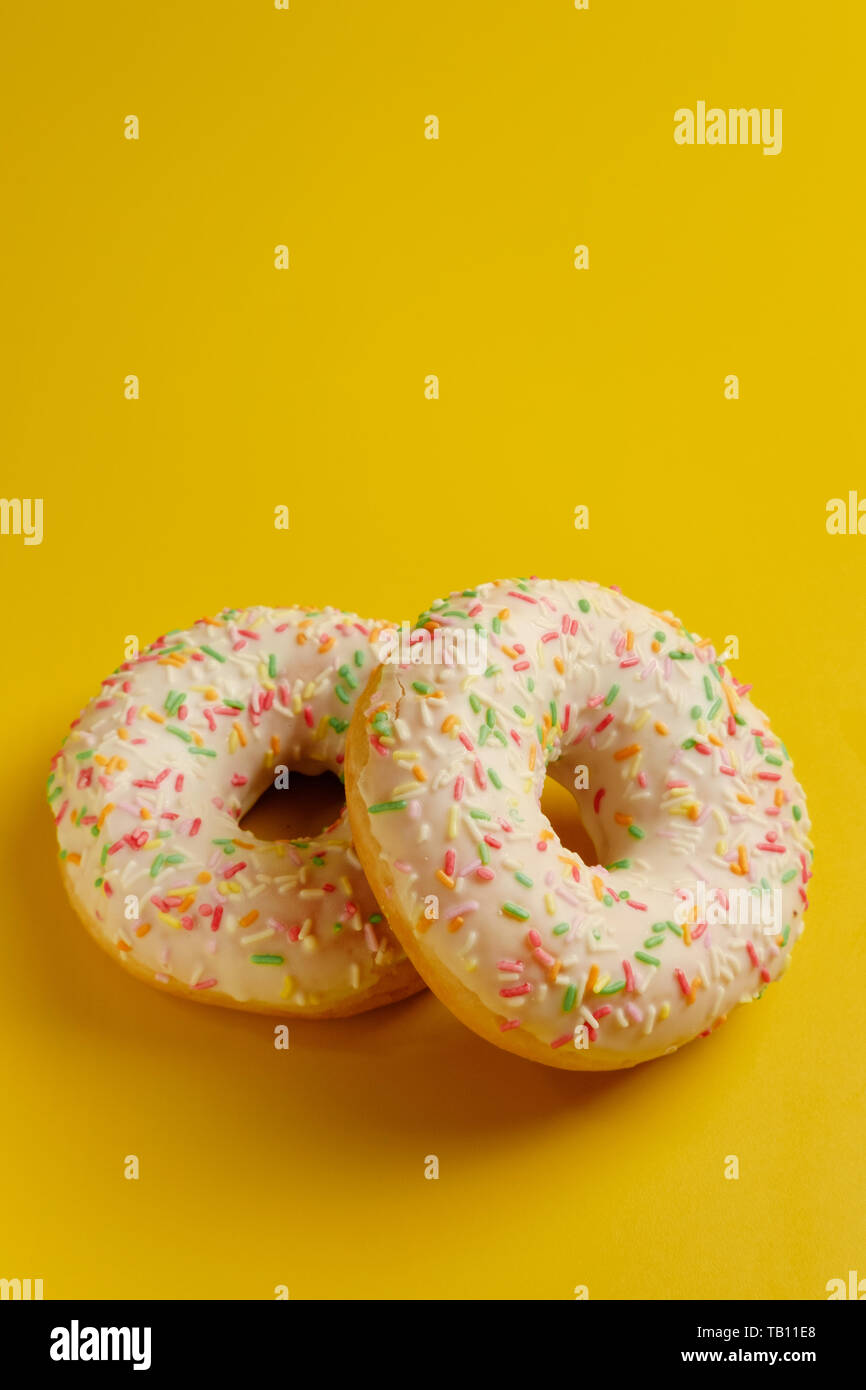 two white donuts on yellow background top view copy space Stock Photo