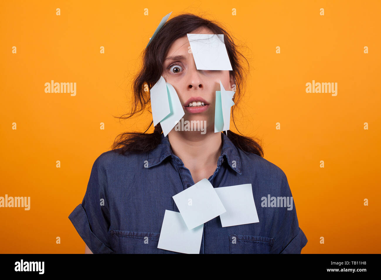 Portrait of cute young woman overwhelmed of work with sticky notes on ...