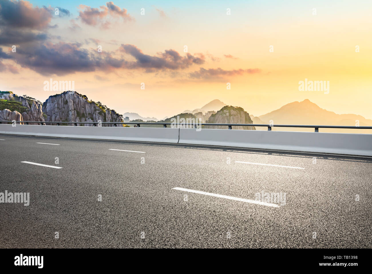 Asphalt highway road and beautiful huangshan mountains nature landscape at sunrise Stock Photo