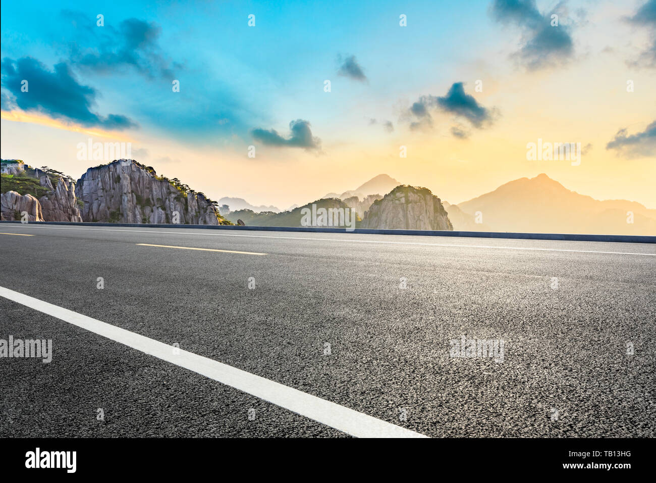 Asphalt highway road and beautiful huangshan mountains nature landscape at sunrise Stock Photo