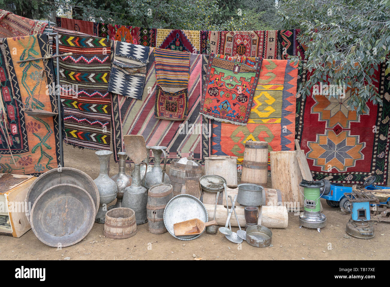 https://c8.alamy.com/comp/TB17XE/old-carpets-metal-jugs-wooden-barrels-and-other-kitchen-utensils-are-sold-at-a-flea-market-in-tbilisi-georgia-TB17XE.jpg