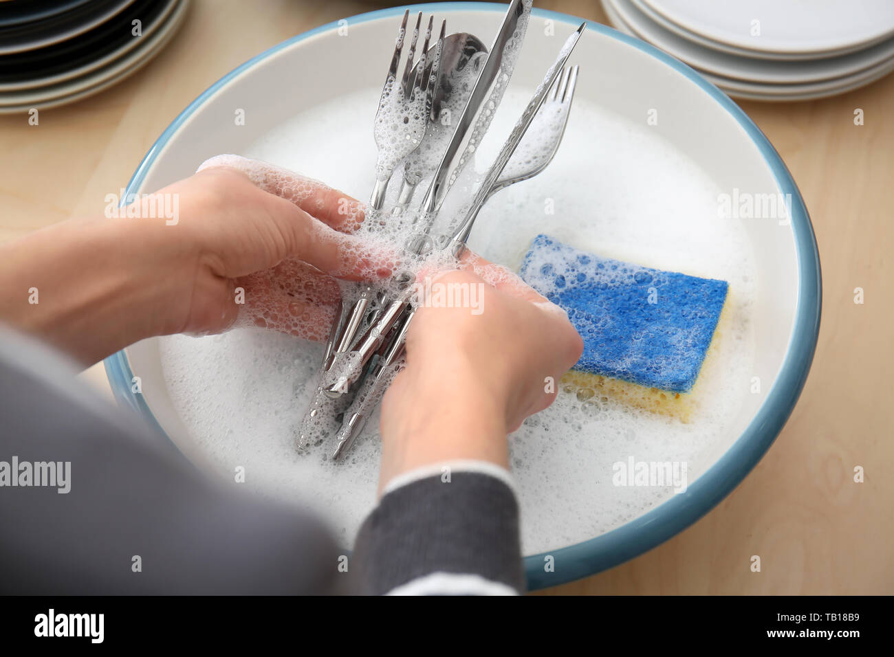 Woman washing cutlery in kitchen Stock Photo - Alamy