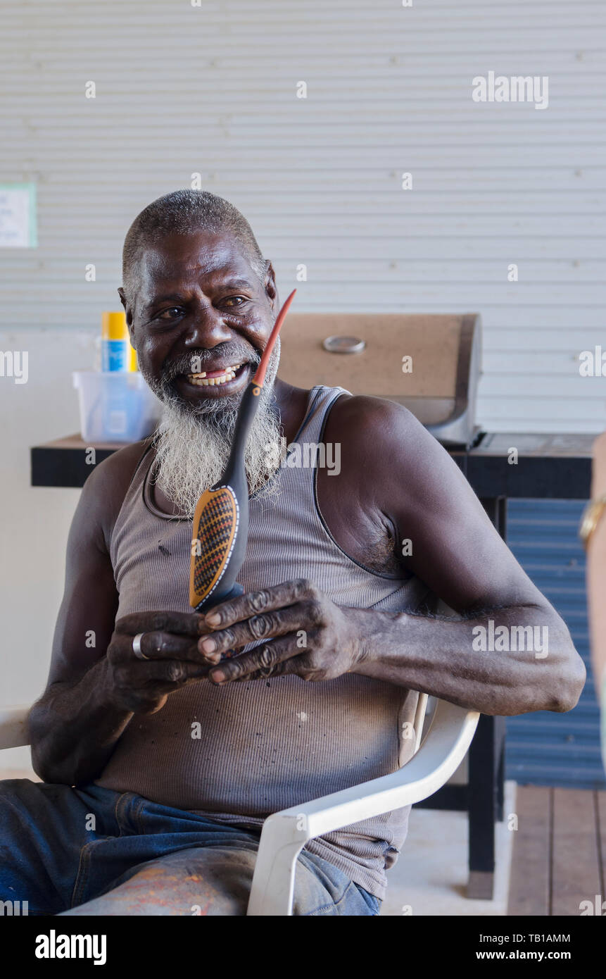 Tiwi Islander artist proudly signing one of his Tiwi bird wooden carvings Stock Photo