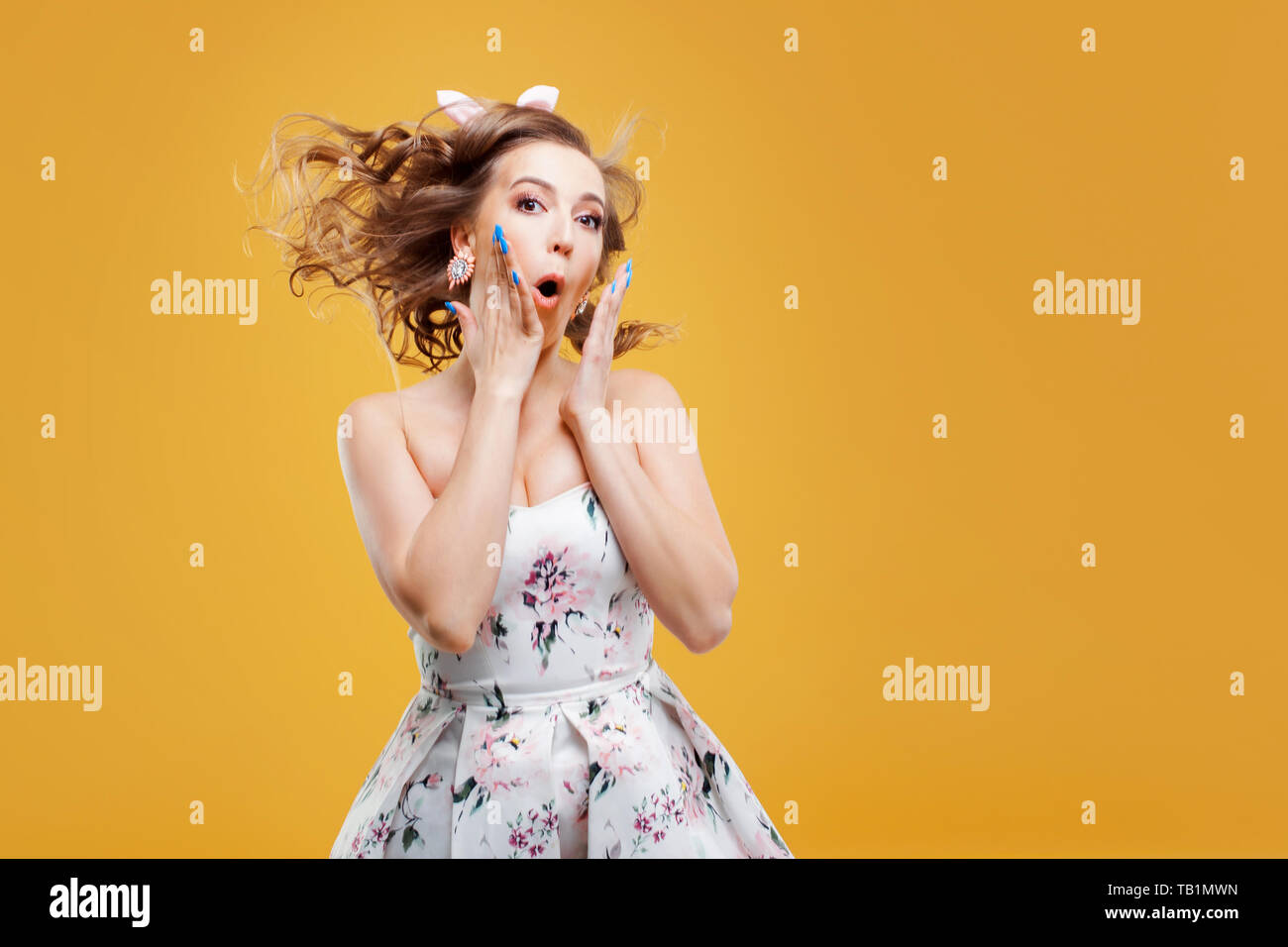 Wow super shock news, portrait of girl in pin up style. Enthusiastic young woman on a cheerful yellow background Stock Photo