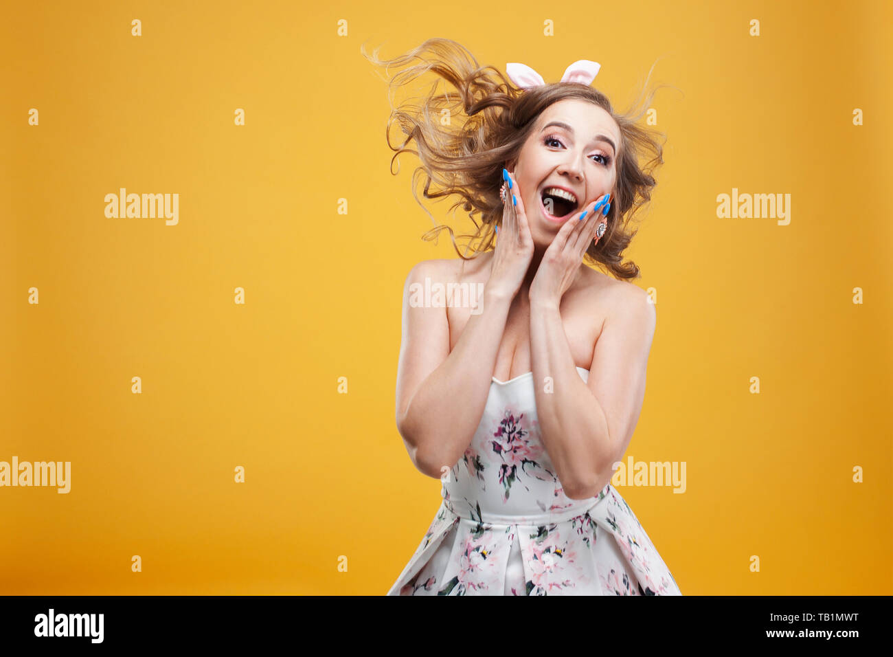 Wow super shock news, portrait of girl in pin up style. Enthusiastic young woman on a cheerful yellow background Stock Photo