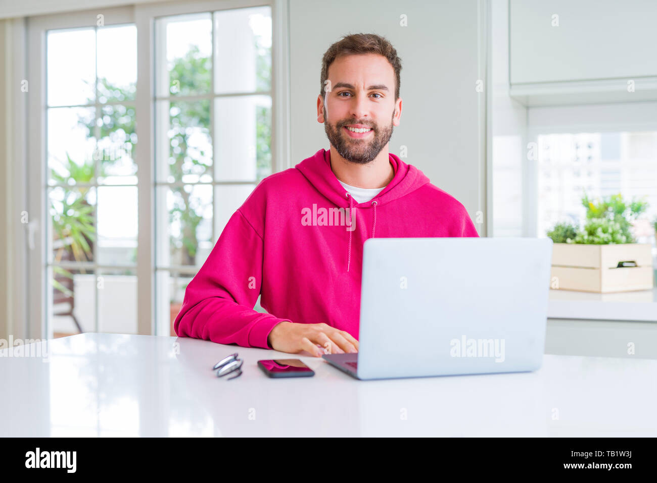 Handsome man working using computer laptop with a happy and cool smile ...